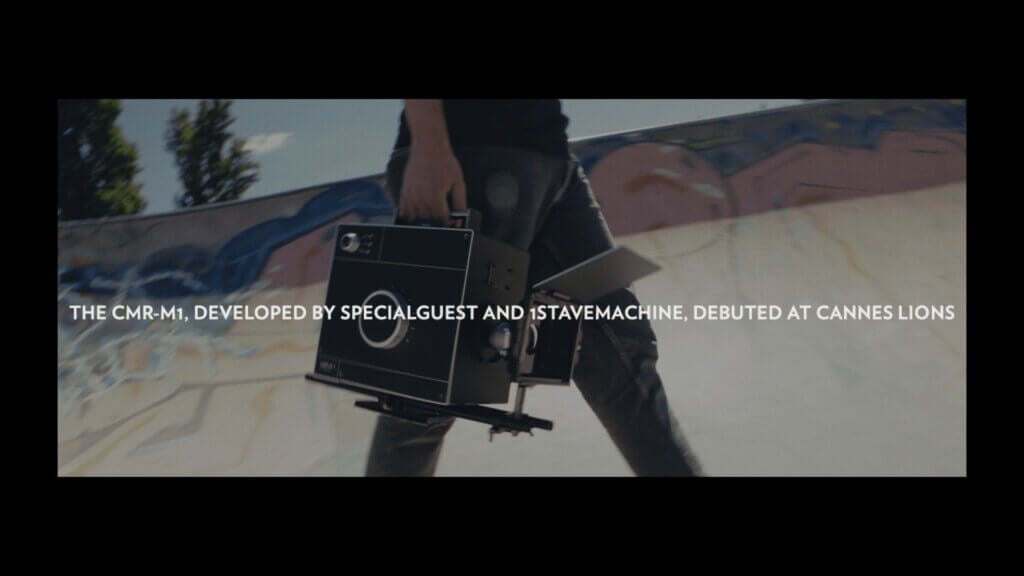 A person holds a large black AI camera at their side while walking outdoors; text over image mentions the CMR-M1 Camera debuted at Cannes Lions.
