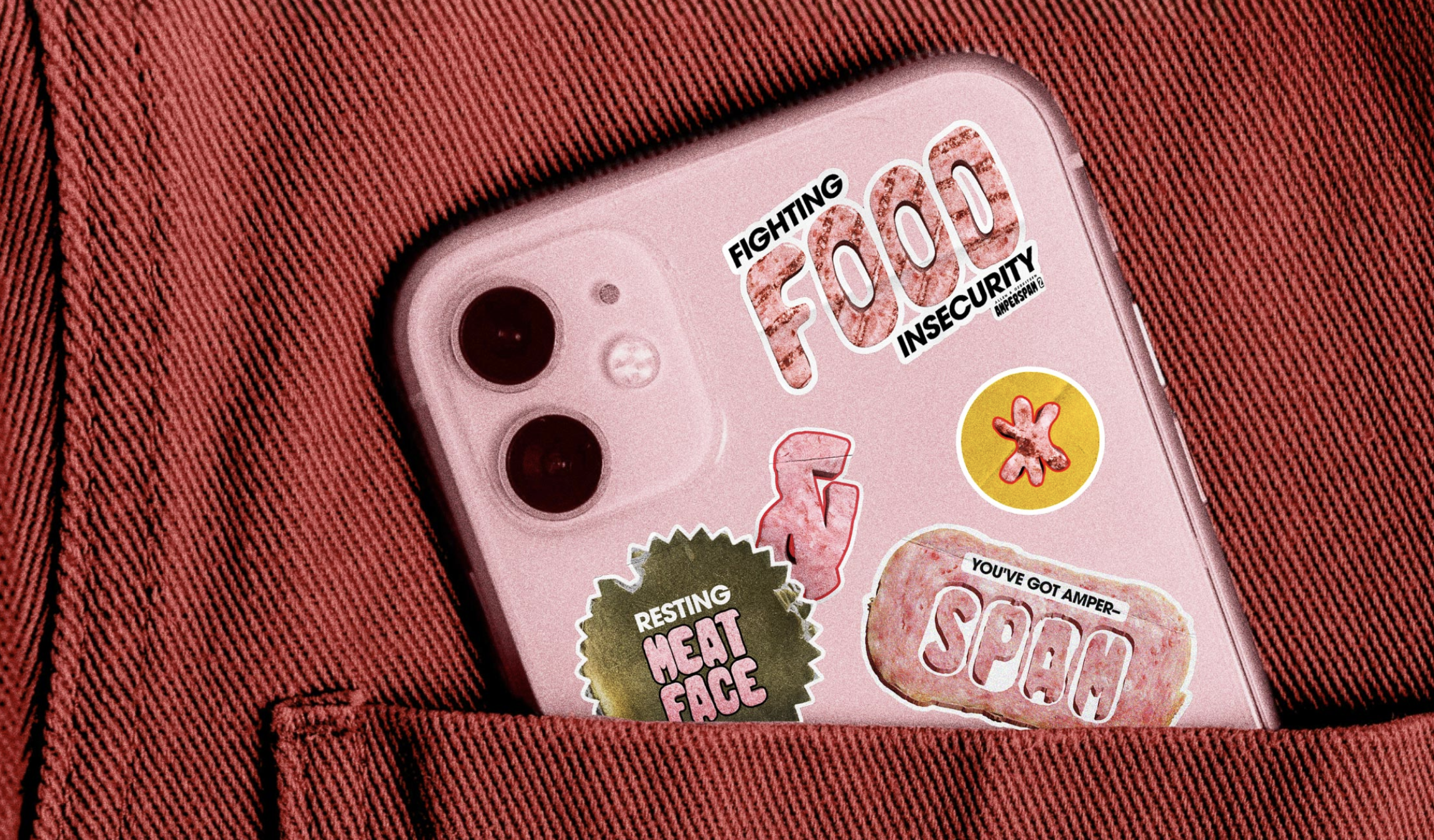A pink smartphone with stickers reading Fighting Food Insecurity, Resting Meat Face, and You’ve Got Ameri... Amperspam in the back pocket of pink jeans, styled with A&G flair and more fonts for a playful touch.