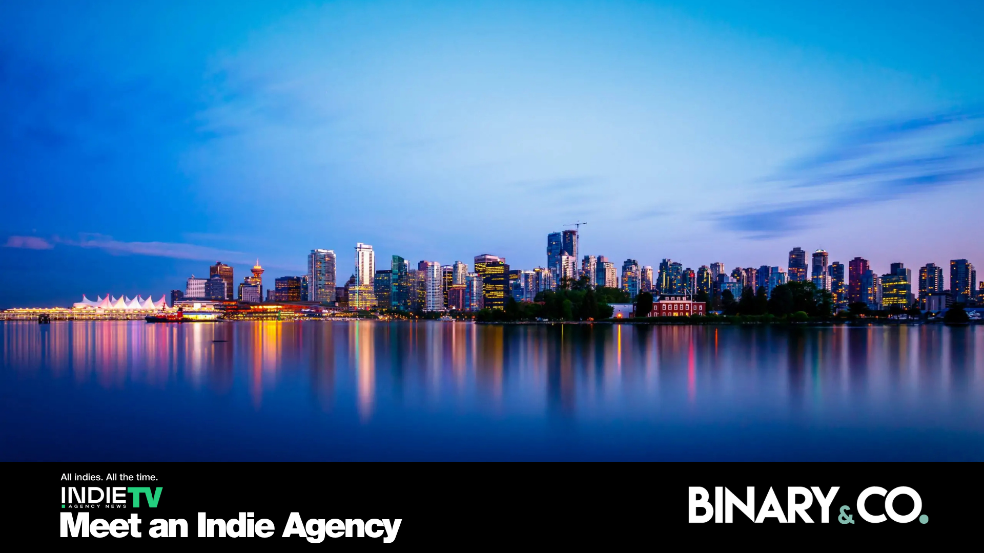 A city skyline at dusk is reflected in calm water, with a clear blue sky above. Text at the bottom reads: Meet an Indie Agency, INDIE TV, Binary & Co.—where creativity rises as reliably as your favorite pizza delivery.