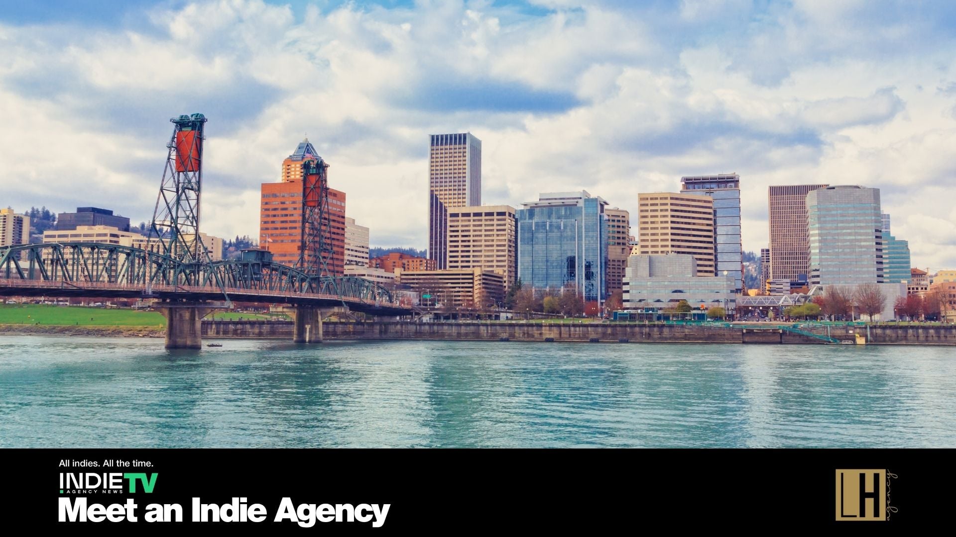 Downtown Portland city skyline with bridges and buildings reflected in the Willamette River, under a partly cloudy sky. A text overlay promotes IndieTV and Left Hand Agency, highlighting their expertise in helping indie creators turn creativity into success stories that look good on any balance sheet.